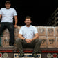 Sebastian Ramírez with a friend sitting on a truck packed with boxes of fresh coffee ready to be shipped.