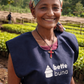 Female coffee producer standing in a coffee nursery at Bette Buna with young plants and drying beds in the background