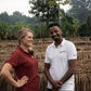 Hester and Dawid standing beside raised drying beds at Bette Buna in Huila, surrounded by processing structures and vegetation
